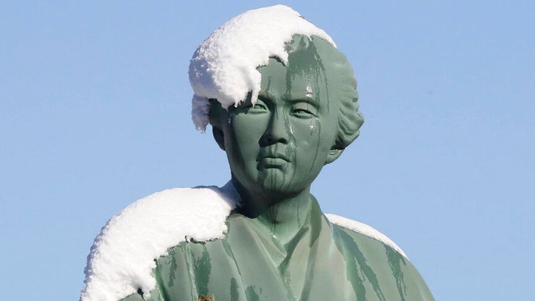 La neige recouvre une statue de Ryoma Sakamoto devant la gare de Kochi dans la ville de Kochi le 24 décembre 2022. (The Yomiuri Shimbun via AP Images)