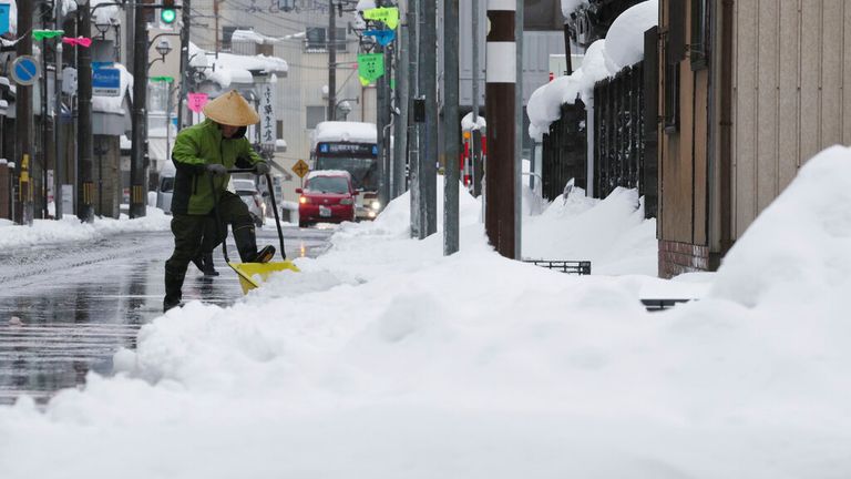A local resident removes snow in Ono, Fukui Prefecture on Dec. 24, 2022. According to the Meteorological Agency, heavy snow has fallen on many parts of Japan and some western cities have renewed records. The agency has warned of blizzard conditions and high waves, which may disrupt traffic railways, and airlines systems.( The Yomiuri Shimbun via AP Images )