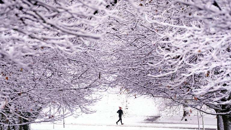 A jogger runs through the snow in Greenwich Park, southeast London