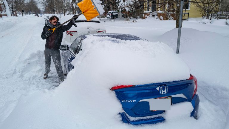 Christian Parker of Buffalo, N.Y., shovels out his car in the Elmwood Village neighborhood of Buffalo, N.Y. Monday, Dec. 26, 2022, after a massive snow storm blanketed the city. Along with drifts and travel bans, many streets were impassible due to abandoned vehicles. (AP Photo/Craig Ruttle)