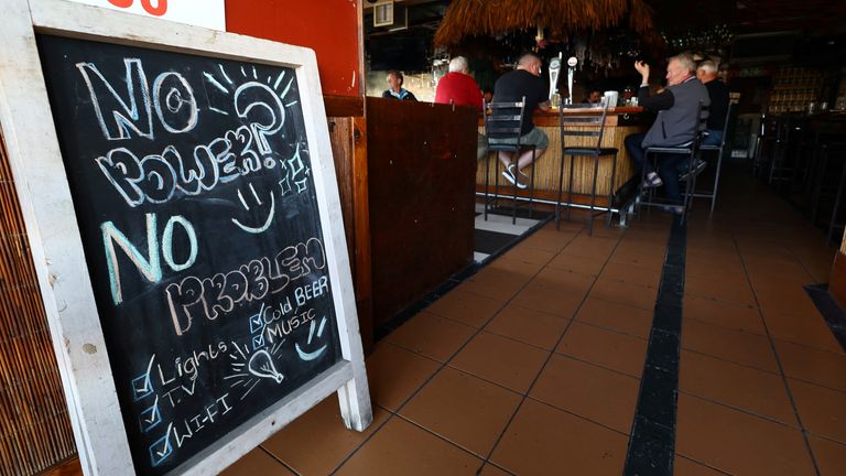 A message on a board at the entrance of a shop is seen as electricity issues continue due to South Africa's struggling power utility Eskom implementing regular power cuts - called 'load-shedding' - because of ageing coal-fired power stations, in Cape Town, South Africa, September 21, 2022. REUTERS/Esa Alexander
