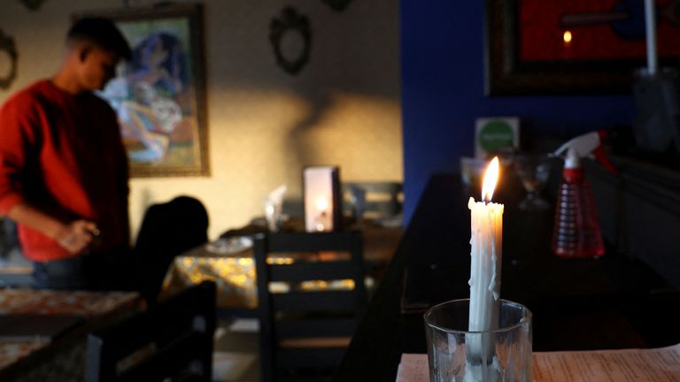 Un restaurante usa velas mientras la empresa de energía de Sudáfrica, Eskom, pierde energía regularmente, lo que se denomina 