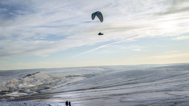 A paraglider over Marsden Moor in the South Pennines. Snow and ice have swept across parts of the UK, with cold wintry conditions set to continue for days. Picture date: Friday December 16, 2022.
