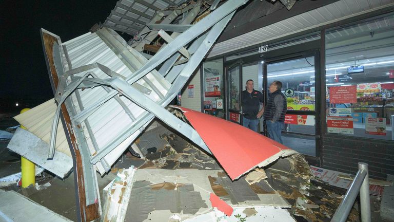A Winn-Dixie employee talks to a customer telling them the store is closed after the facade had fallen down due to a tornado in Gretna, La., in Jefferson Parish neighboring New Orleans, Wednesday, Dec. 14, 2022. No one was injured at the store. (AP Photo/Matthew Hinton)