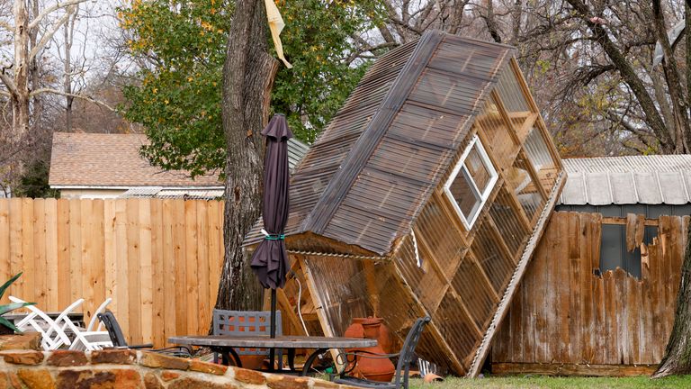 A greenhouse is erected over a fence in the backyard of Randy Popiel's home Tuesday, Dec. 12, after a possible tornado in Grapevine, Texas.  13th, 2022.  (El..as Valverde II/The Dallas Morning News via AP)