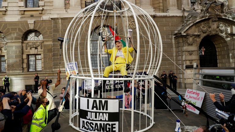 FILE - Fashion designer Vivienne Westwood sits suspended in a giant bird cage in protest against the extradition of WikiLeaks founder Julian Assange to the U.S., outside the Old Bailey court, in London on July 21, 2020. Westwood, an influential fashion maverick who played a key role in the punk movement, died Thursday, Dec. 29, 2022, at 81. (AP Photo/Matt Dunham, File)