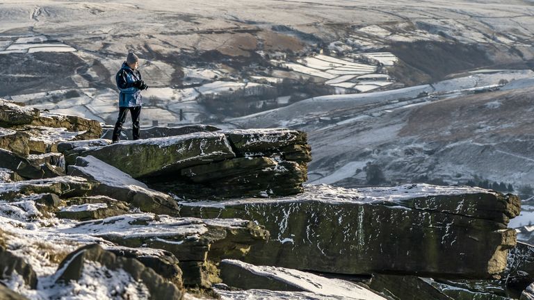 A man walks on Marsden Moor in the South Pennines. Snow and ice have swept across parts of the UK, with cold wintry conditions set to continue for days. Picture date: Friday December 16, 2022.