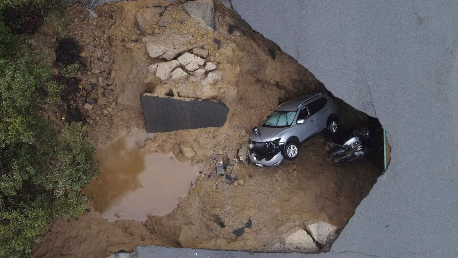 Sinkholes swallow cars as torrential rain batters California - and another powerful storm is coming