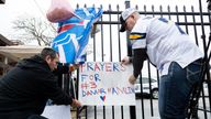 Football fans tape a sign to a fence during a vigil outside the University of Cincinnati Medical Center where Buffalo Bills safety Damar Hamlin lies in critical condition, after suffering a cardiac arrest during the January 2 National Football League (NFL) game against the Cincinnati Bengals, in Cincinnati, Ohio, U.S., January 3, 2023. REUTERS/Megan Jelinger