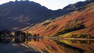 File photo dated 11/10/20 of autumnal reflections in lake Buttermere in the Lake District, Cumbria, as the Government has come under fire for its record of "failing to keep promises" on the environment ahead of global talks aimed at reversing nature losses.