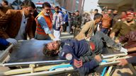 Workers and volunteers carry an injured victim to a hospital in Peshawar, Pakistan