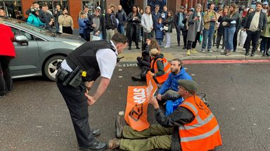 A police officer speaks to Just Stop Oil activists blocking the road on Commercial Street in east London.