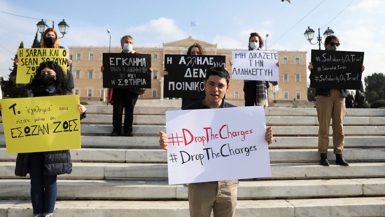 Sean Binder, one of 24 defendants, holds a sign during an Amnesty International protest in Athens, Greece, in 2021. 