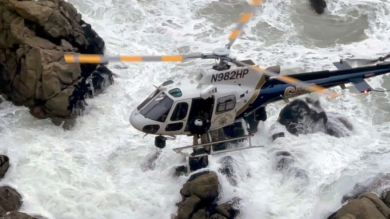 This image from video provided by San Mateo County Sheriff&#39;s Office shows a helicopter rescue after a Tesla plunged off a Northern California cliff along the Pacific Coast Highway, Monday, Jan. 2, 2023, near an area known as Devil&#39;s Slide, leaving four people in critical condition, a fire official said. (San Mateo County Sheriff&#39;s Office via AP)