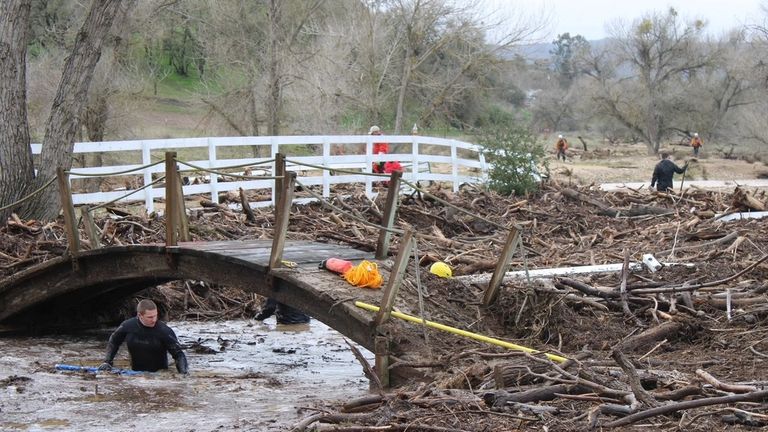 A rescue team searches for 5-year-old Kyle Doan who was swept away by raging floodwaters, in San Luis Obispo County, California 