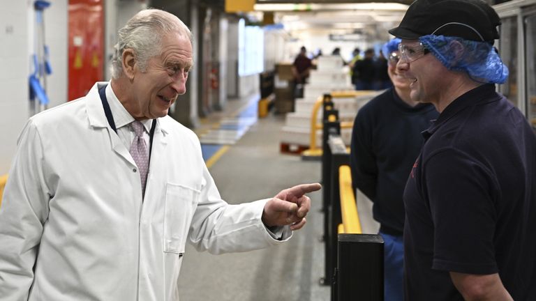 Charles jokes with a pair of Kellogg's factory workers. Pic: PA