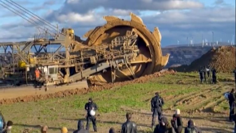 Footage shows protesters in Lutzerath cheering and clapping as a huge bucket-wheel excavator stops turning as police look on.