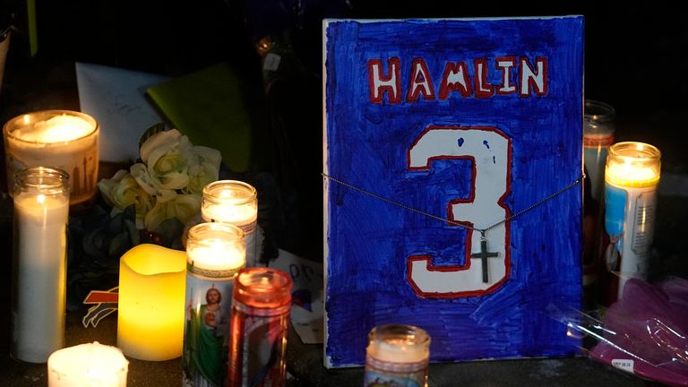 A painting that shows the number of Buffalo Bills&#39; Damar Hamlin is illuminated by candles during a prayer vigil outside University of Cincinnati Medical Center, Tuesday, Jan. 3, 2023, in Cincinnati. Hamlin was taken to the hospital after collapsing on the field during an NFL football game against the Cincinnati Bengals on Monday night. (AP Photo/Darron Cummings)