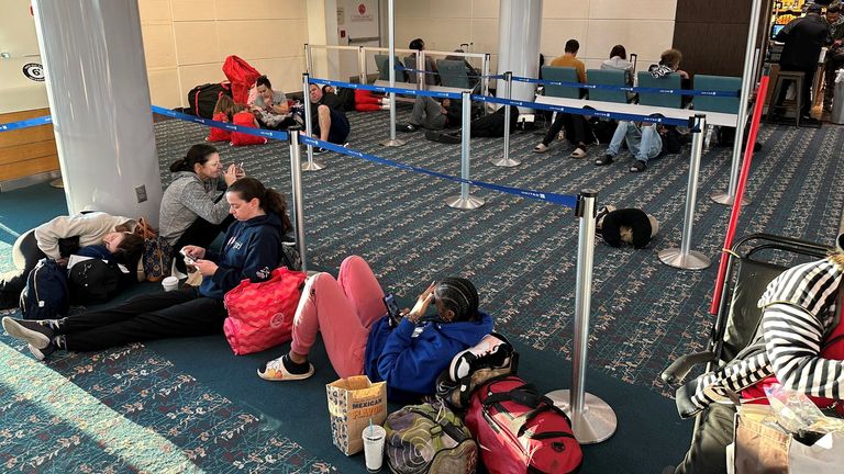 Stranded passengers wait at Orlando International Airport as flights are grounded after an FAA system outage in Orlando, Fla.