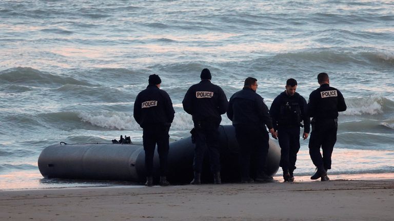 French policemen stand beside a dinghy lying on the beach in Sangatte near Calais. File pic
