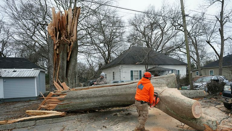 Ekipler, Georgia şehrini vuran bir kasırganın ardından Griffin'de devrilmiş bir ağacı temizlemek için çalışıyor.  Resim: AP