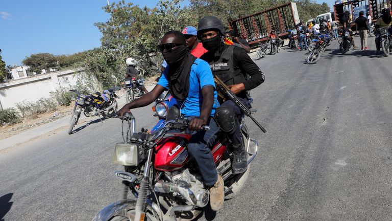 A police officer rides in the back of a motorcycle during a protest for the recent killings of police officers by armed gangs, in Port-au-Prince, Haiti January 26, 2023. REUTERS/Ralph Tedy Erol
