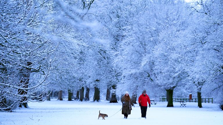 People walk a dog in snowy conditions near Hexham. Drivers have been warned to leave extra time for their Monday morning commute due to icy roads during rush hour, following a weekend of wintry weather. Picture date: Monday January 16, 2023.