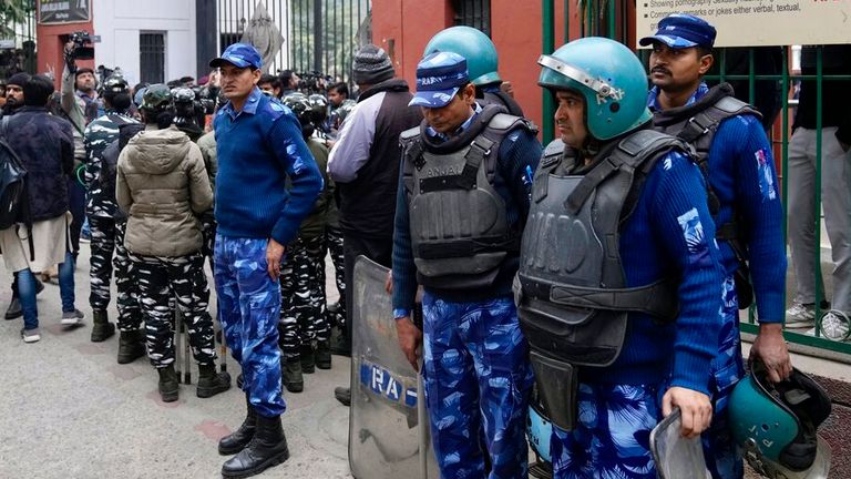 Güvenlik personeli, 25 Ocak 2023 Çarşamba, Yeni Delhi'deki Jamia Millia Islamia Üniversitesi'nin ana kapısını koruyor. Bir öğrenci grubunun, Hindistan Başbakanı Narendra Modi'yi inceleyen yasaklanmış bir belgeseli göstermeyi planladıklarını söylemesinin ardından üniversitede gerilim tırmandı. 39;'in 2002'deki Müslüman karşıtı isyanlar sırasındaki rolü, düzinelerce polisin göz yaşartıcı gaz ve isyan teçhizatı ile kampüs kapılarının dışında toplanmasına neden oldu.  (AP Fotoğrafı/Manish Swarup)
