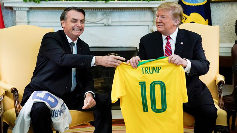 Brazil&#39;s President Jair Bolsonaro presents a Brazil naitonal soccer team jersey to U.S. President Donald Trump after Trump gave him a U.S. soccer team jersey during a meeting in the Oval Office of the White House in Washington, U.S., March 19, 2019. REUTERS/Kevin Lamarque

