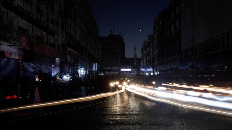 Vehicle lights cause light lines on the road along the market during a nationwide power breakdown on January 23, 2023 in Karachi, Pakistan.  REUTERS/Akhtar Soomro