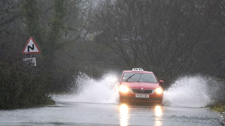 A car makes it's way through flood water on Kent Lane, near to Ibsley in Hampshire. The Met Office has issued warnings for heavy rains and floods, falling heaviest in western areas but causing wet and windy conditions all over the country. Picture date: Tuesday January 10, 2023.
