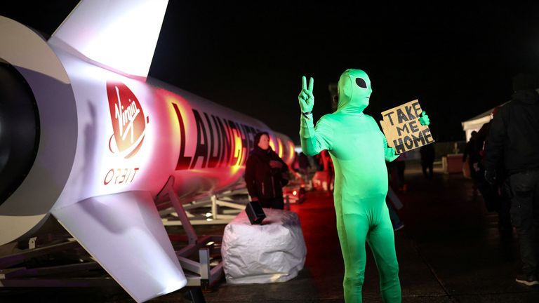 A man in an alien costume poses for photographers during a spectator event for Virgin Orbit's LauncherOne's first UK launch at Newquay, Cornwall Airport, Newquay, England, January 9, 2023. REUTERS/Henry Nicholls
