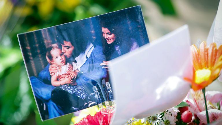A photo of a young Lisa Marie Presley with her parents, Elvis Presley and Priscilla Presley in a bouquet of flowers at her memorial service. Pic: Patrick Lantrip/Daily Memphian/AP