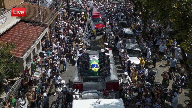 The casket of late Brazilian soccer great Pele is draped in the Brazilian and Santos FC soccer club flags as his remains are transported from Vila Belmiro stadium, where he laid in state, to the cemetery during his funeral procession in Santos, Brazil, Tuesday, Jan. 3, 2023. (AP Photo/Matias Delacroix)