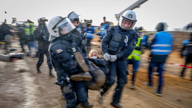 Police officers carry a demonstrator to clear a road at the village Luetzerath near Erkelenz, Germany 
PIC:AP