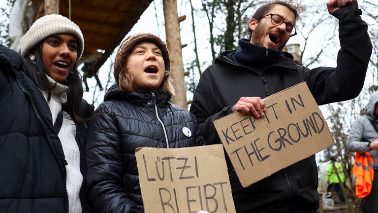Swedish climate activist Greta Thunberg holds a sign that reads &#39;Luetzi stays&#39;, as activists protest against the expansion of the Garzweiler open-cast lignite mine of Germany&#39;s utility RWE, in Luetzerath, Germany