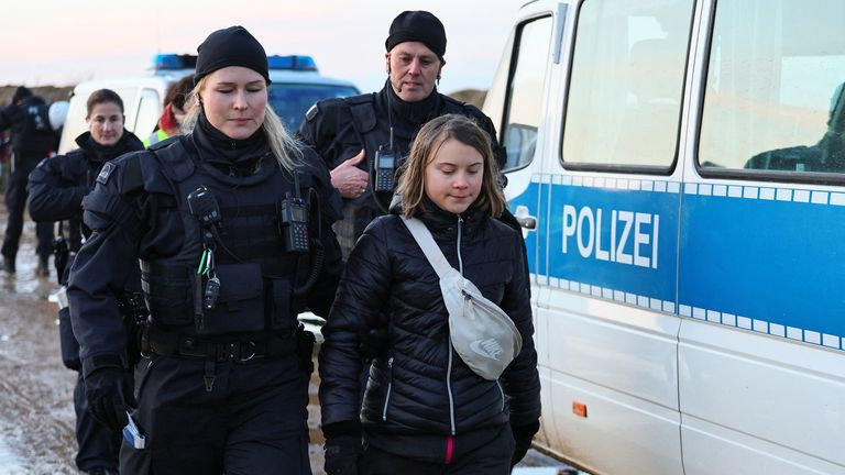 Een politieagent vergezelt klimaatactiviste Greta Thunberg het gebied uit op de dag van een protest tegen de uitbreiding van de Garzweiler dagbouw bruinkoolmijn van het Duitse nutsbedrijf RWE naar Luetzerath 