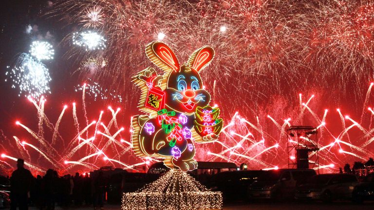 Fireworks are seen behind a neon-light rabbit celebrating the Spring Festival. Pic: AP