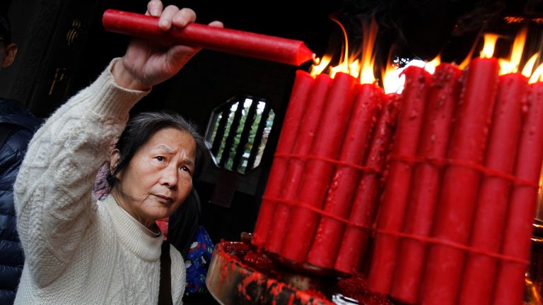 A Taiwanese woman lights up a candle to mark the new year. Pic: AP