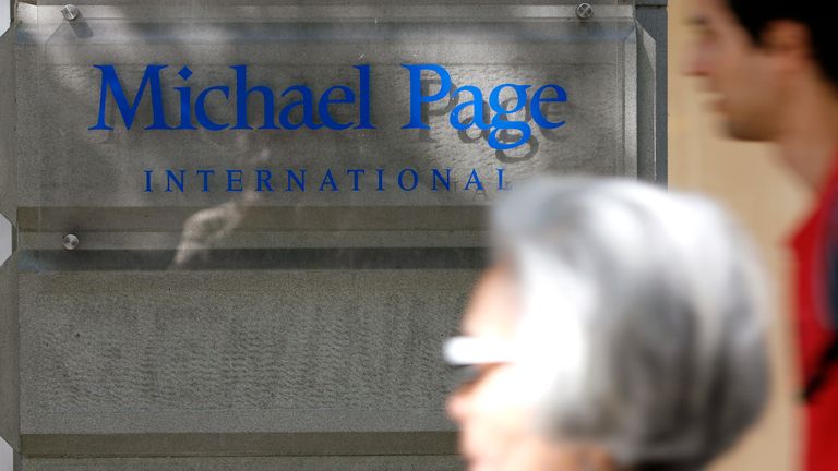 People walk past an office of British recruitment company Michael Page in Zurich.