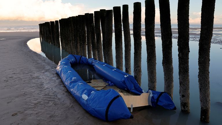 A damaged inflatable dinghy lies on the beach in Sangatte near Calais