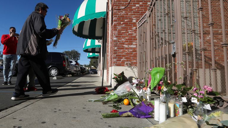 A man lays flowers at the Star Ballroom Dance Studio