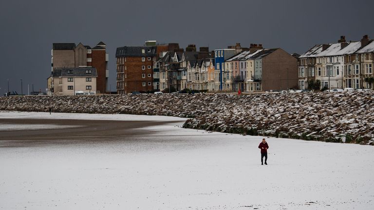 The Continuing Cold weather across the United Kingdom sees Hail Turns the Beaches of Morecambe White 

