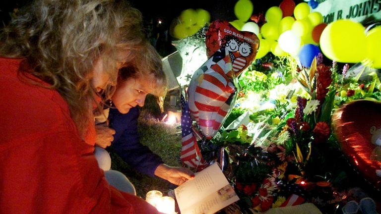 Carol Kern (L-front) of Seabrook, Texas, and Kimberlee Kyle (back) of League City, Texas, read tributes to the astronauts killed in the space shuttle disaster at a makeshift memorial of flowers, balloons and other memories outside left on February 1, 2003 at NASA's Johnson Space Center in Houston .  The Space Shuttle Columbia, carrying a crew of seven, disintegrated earlier that day 200,000 feet above Texas.  REUTERS/Jim Bourg JRB/CP