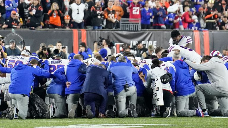 Buffalo Bills players and staff pray for Buffalo Bills&#39; Damar Hamlin during the first half of an NFL football game against the Cincinnati Bengals, Monday, Jan. 2, 2023, in Cincinnati. The game has been postponed after Buffalo Bills&#39; Damar Hamlin collapsed, NFL Commissioner Roger Goodell announced. (AP Photo/Joshua A. Bickel)