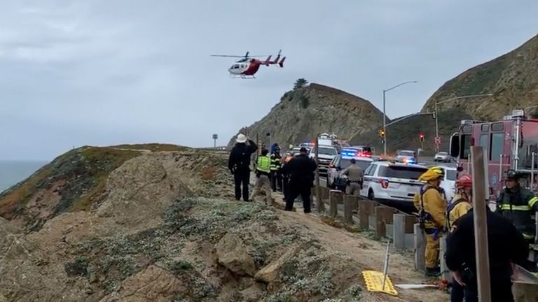 In this image from video provided by Cal Fire San Mateo, Santa Cruz Unit, emergency personnel respond to the scene after a Tesla plunged off a cliff along the Pacific Coast Highway, Monday, Jan. 2, 2023, in Northern California, near an area known as Devil&#39;s Slide, leaving four people in critical condition, a fire official said (Cal Fire San Mateo - Santa Cruz Unit via AP)
