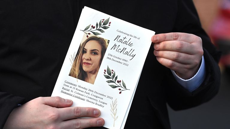 A mourner holds an order of service during the funeral of Natalie McNally