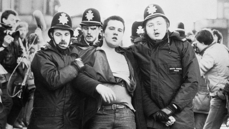 Blood appears to pour down the face of a policeman as his colleagues lead away a picket from outside the NUM HQ in Sheffield today. Miners were picketing a meeting of the union&#39;s executive which is due to vote on whether to hold a national ballot on the continuing strike.
