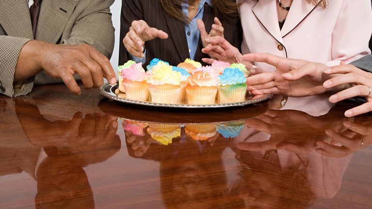 Businesspeople reaching for cakes