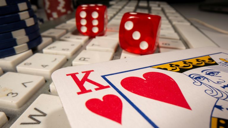 Gambling dice and chips are seen on the keyboard  